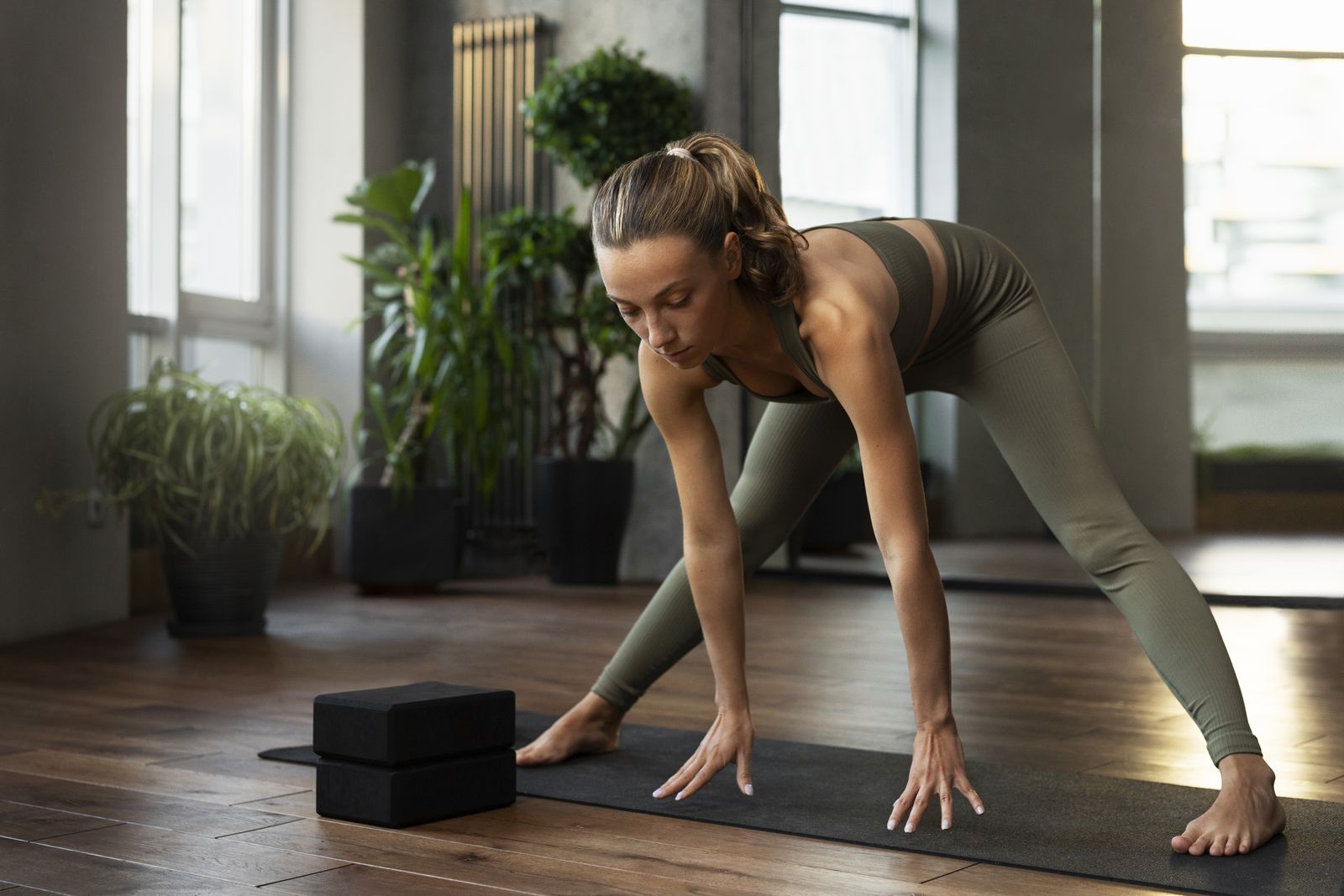 Frau in einer breiten Vorbeuge auf der Yogamatte mit zwei Blöcken