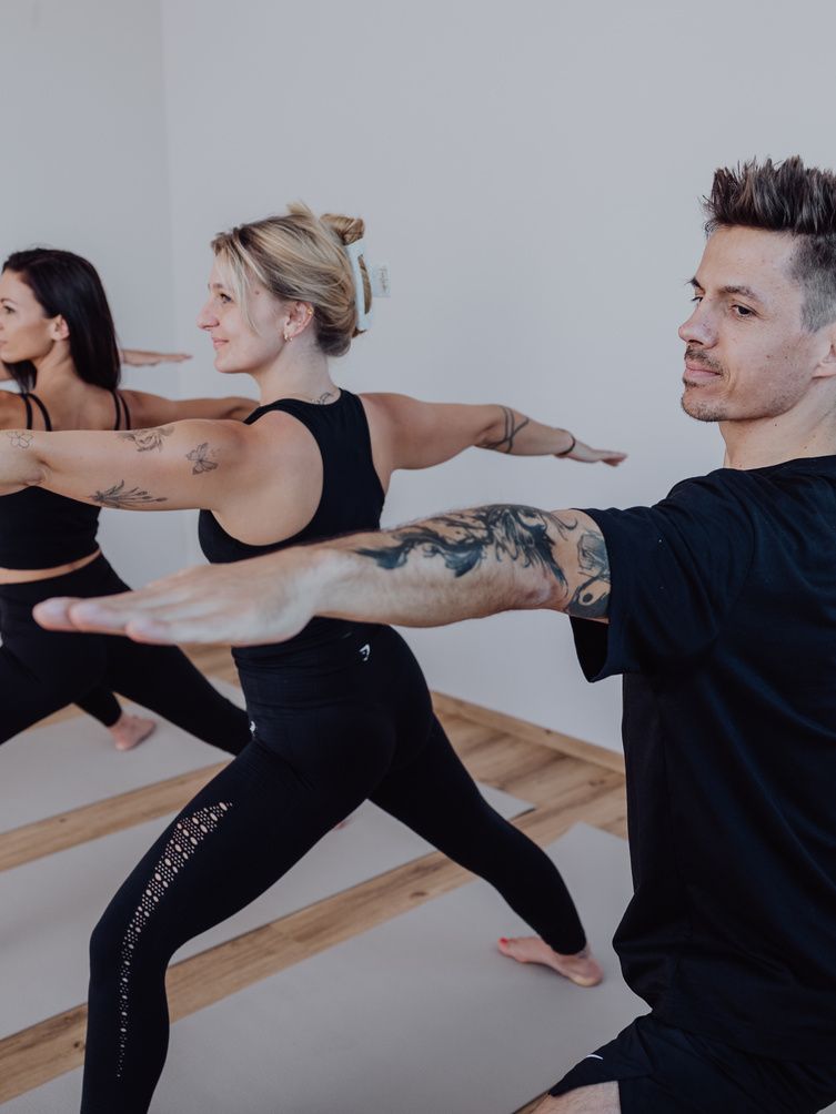 Gruppe in der Kriegerhaltung im Kurs Vinyasa Flow